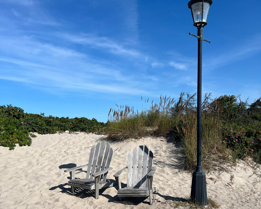 Två stolar på en sandstrand som symboliserar reflektion, samtal och nya perspektiv.